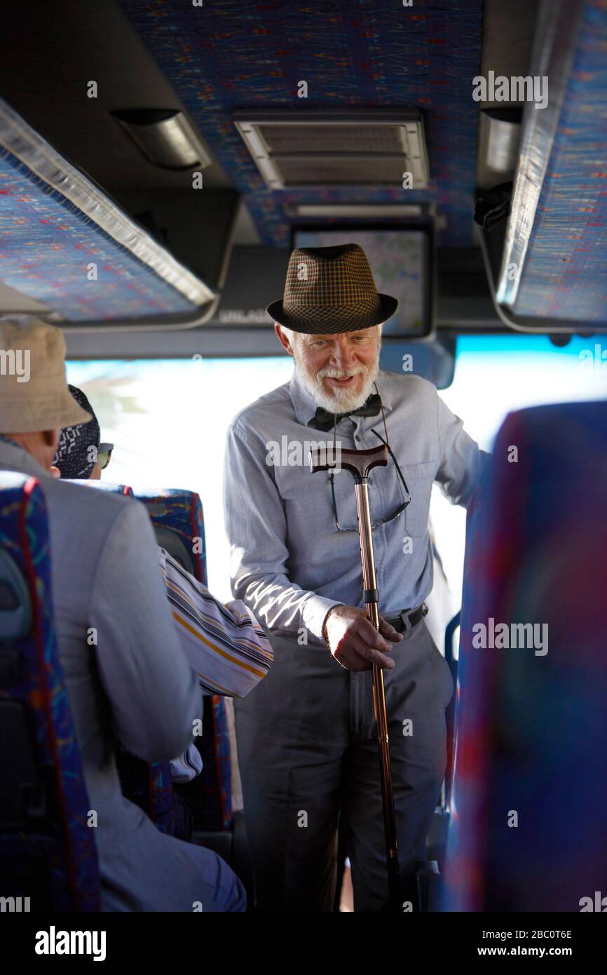 Aktiver Senior in Hut mit Rohrboarding-Tour-Bus Stockfoto