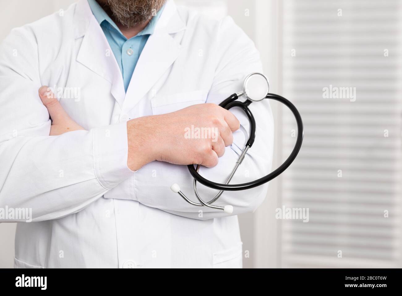 Nahaufnahme von einem männlichen Arzt holding Stethoskop im Büro Stockfoto