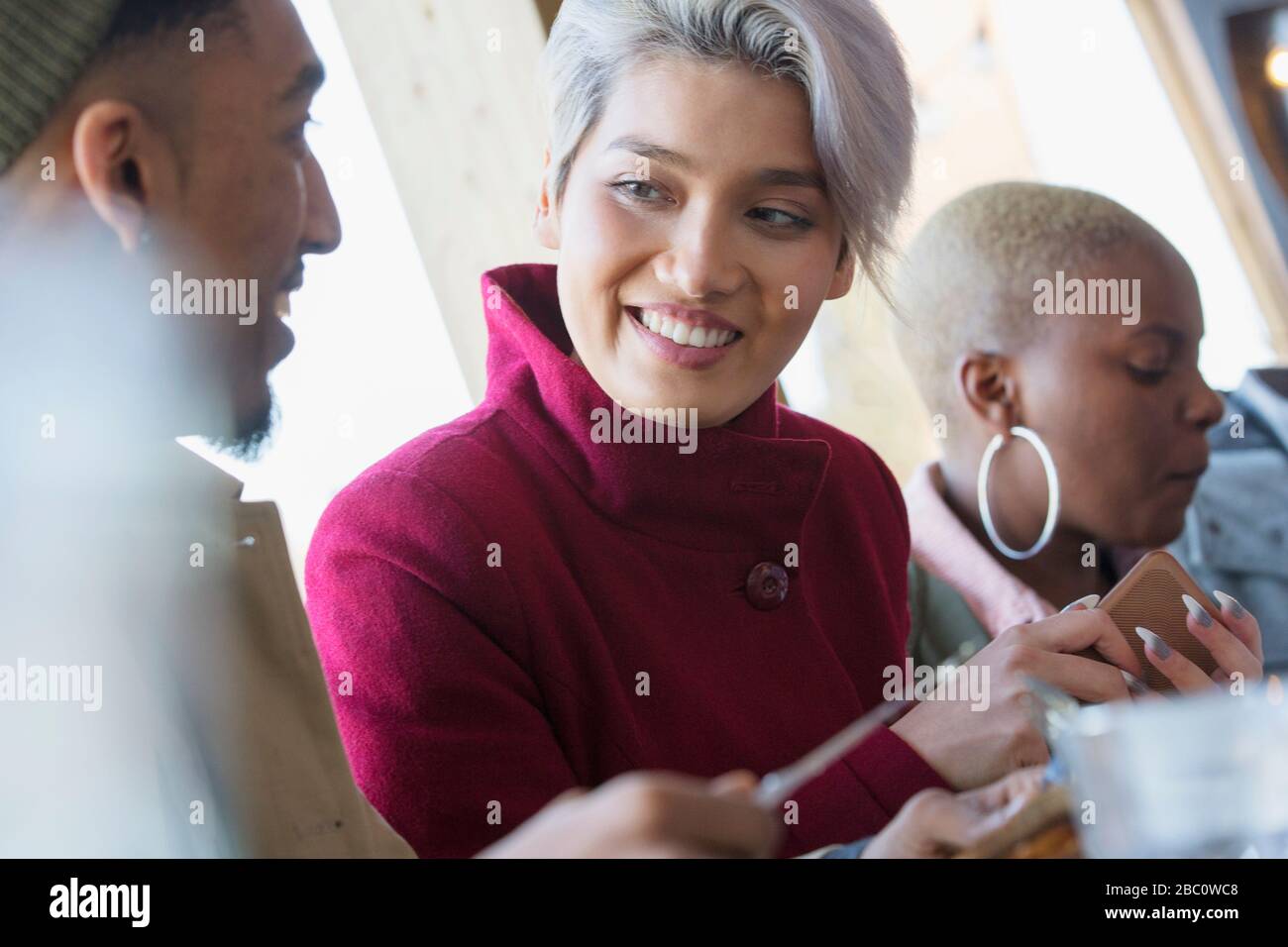 Lächelnde junge Frau im Gespräch mit einem Freund Stockfoto
