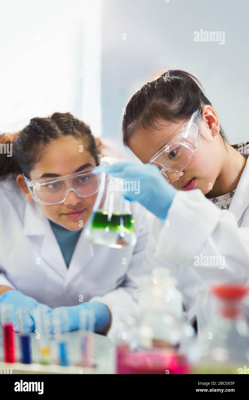 Mädchen Studenten untersuchen Flüssigkeit im Becher und führen wissenschaftliche Experimente im Laborunterricht durch Stockfoto