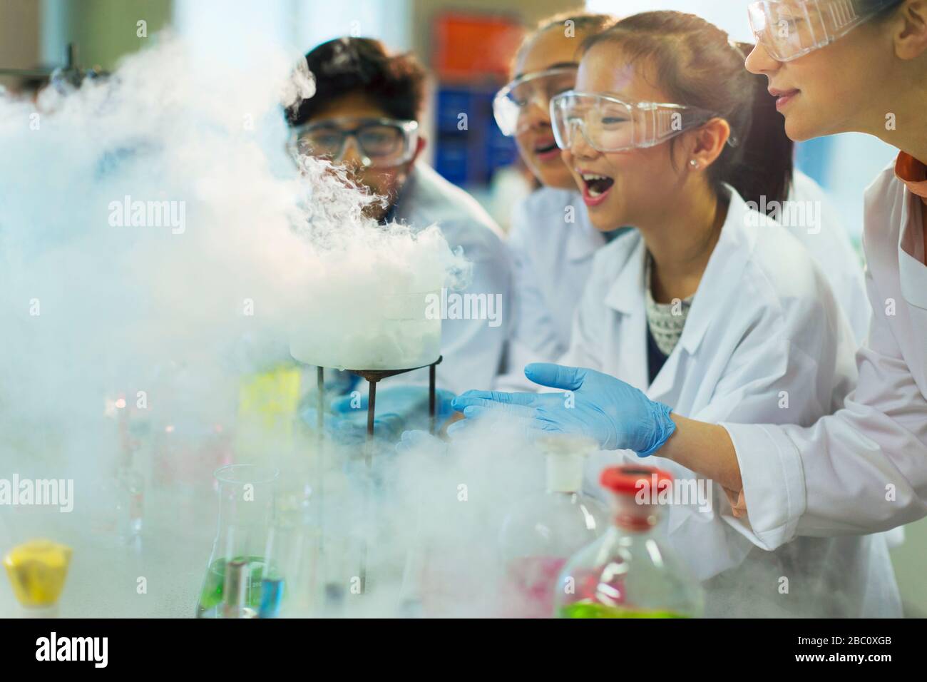 Überraschte, neugierige Studenten beobachten chemische Reaktionen und führen wissenschaftliche Experimente im Laborunterricht durch Stockfoto
