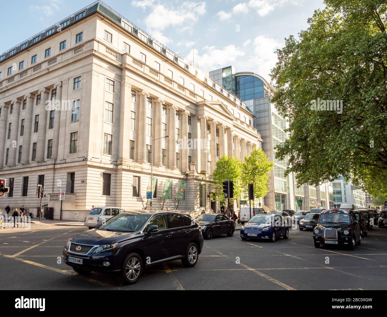 Der Wellcome Trust. Der Hauptsitz der biomedizinischen Forschungsorganisation an der Euston Road im Zentrum Londons mit Vordergrundverkehr. Stockfoto