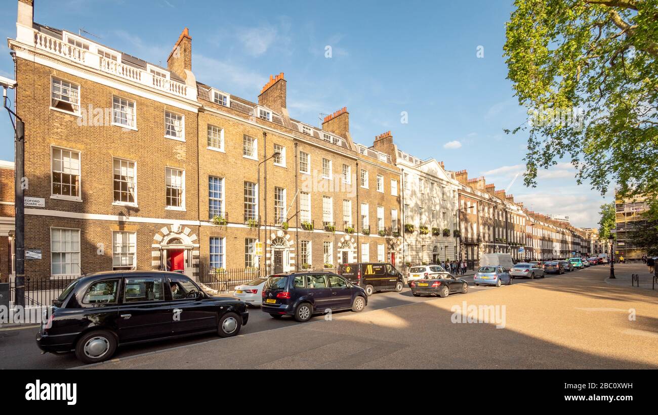 Bedford Square, Bloomsbury, London. Eine Reihenreihe von großen georgianischen Stadthäusern mit zeitgenössischem Verkehr, die die engen Straßen der Stadt füllen. Stockfoto