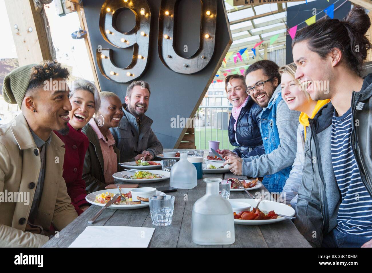 Fröhliche Freunde genießen das Frühstück auf der Außenterrasse des Restaurants Stockfoto