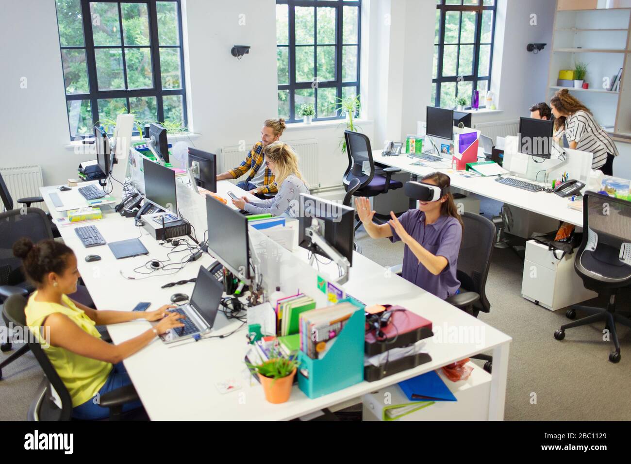 Designer und Computerprogrammierer, die in einem offenen Planbüro arbeiten Stockfoto