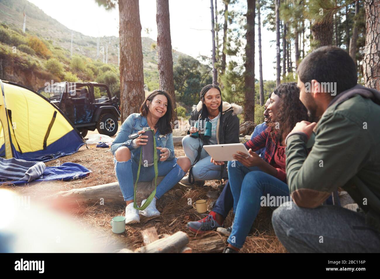 Junge Freunde mit digitalem Tablet auf dem Zeltplatz Stockfoto