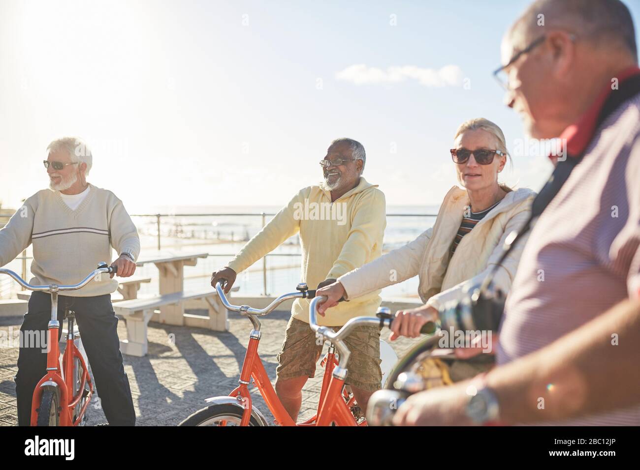 Aktive Senioren fahren auf sonnigen Spazierwegen mit dem Fahrrad Stockfoto