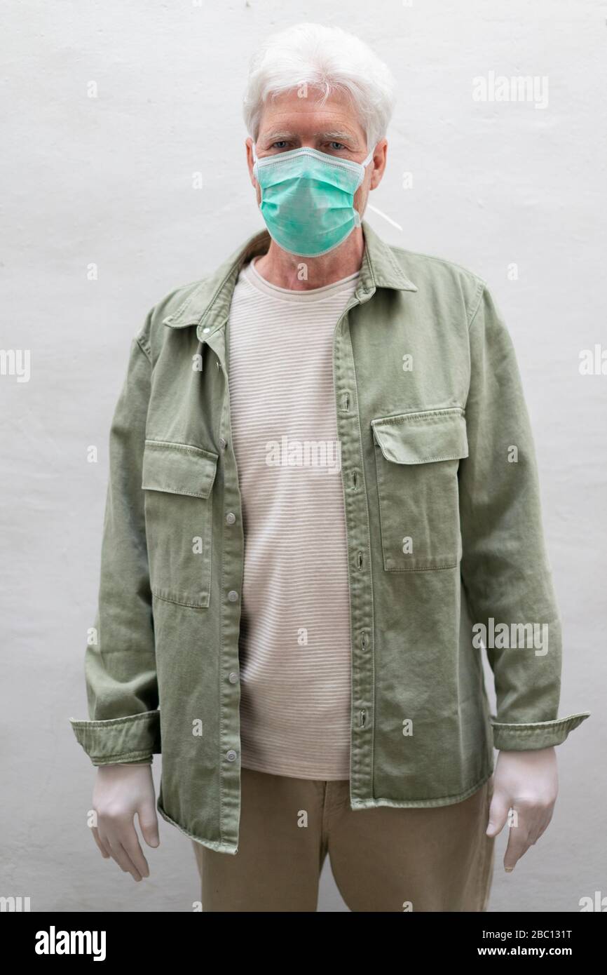 Älterer Mann mit Gesichtsmaske und Schutzmaske Stockfoto