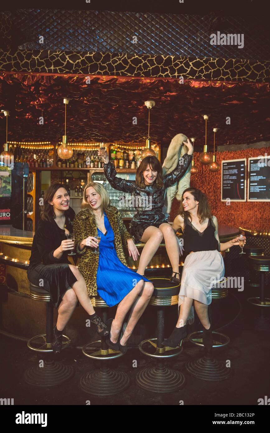 Vier glückliche Frauen sitzen an der Bar in einem Club Stockfoto