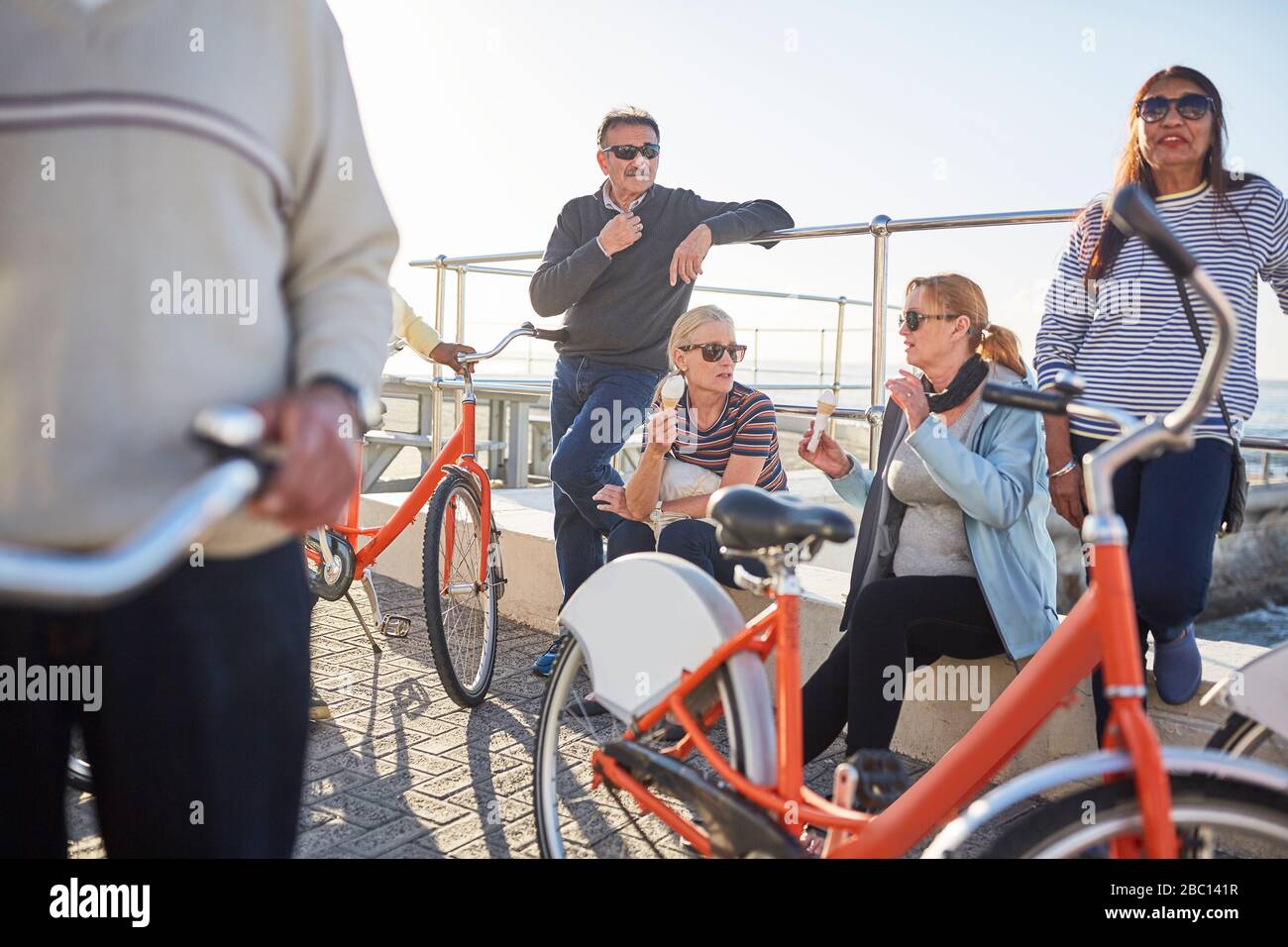 Aktive Seniorentouristen mit Fahrrädern, die Eis essen Stockfoto