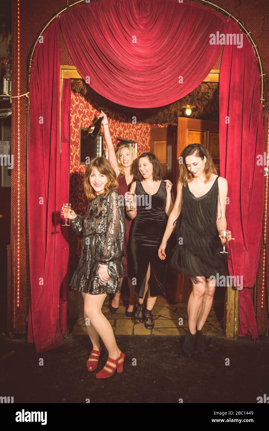 Vier glückliche Frauen, die in einen Club eintreten Stockfoto