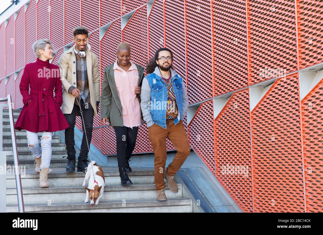 Junge Freunde, die die städtischen, modernen Treppen hinuntergehen Stockfoto