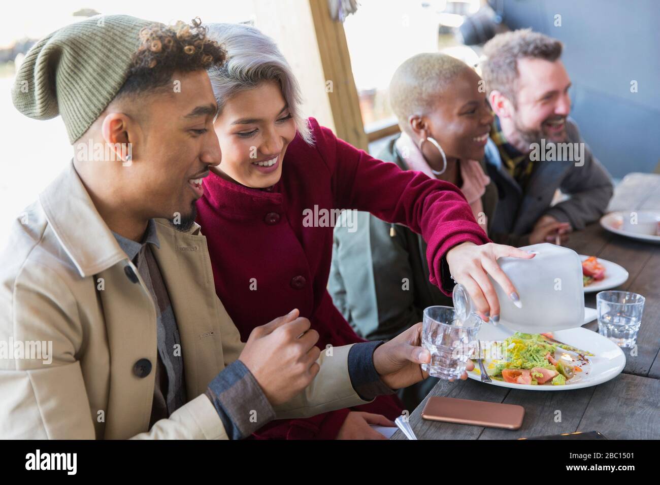 Lächelndes junges Paar, das im Restaurant im Café im Freien speisen kann Stockfoto