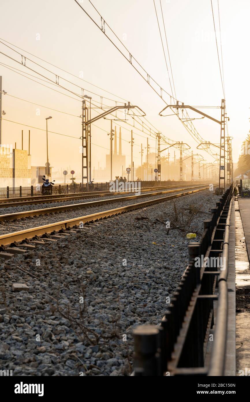Spanien, Barcelona, Badalona, leere Eisenbahnschienen bei Sonnenuntergang Stockfoto