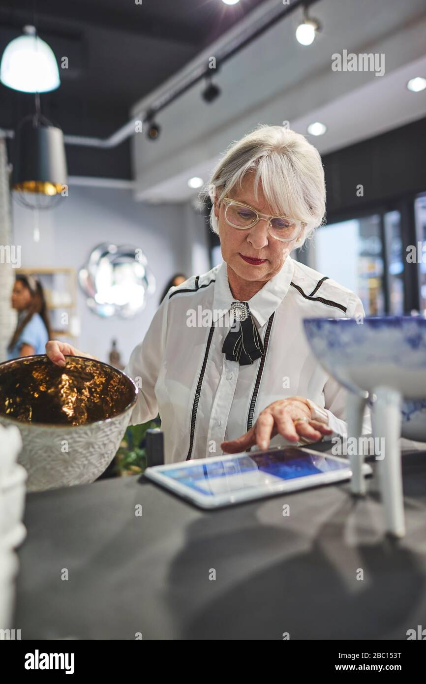 Seniorin mit digitalem Tablet im Innendekor Stockfoto