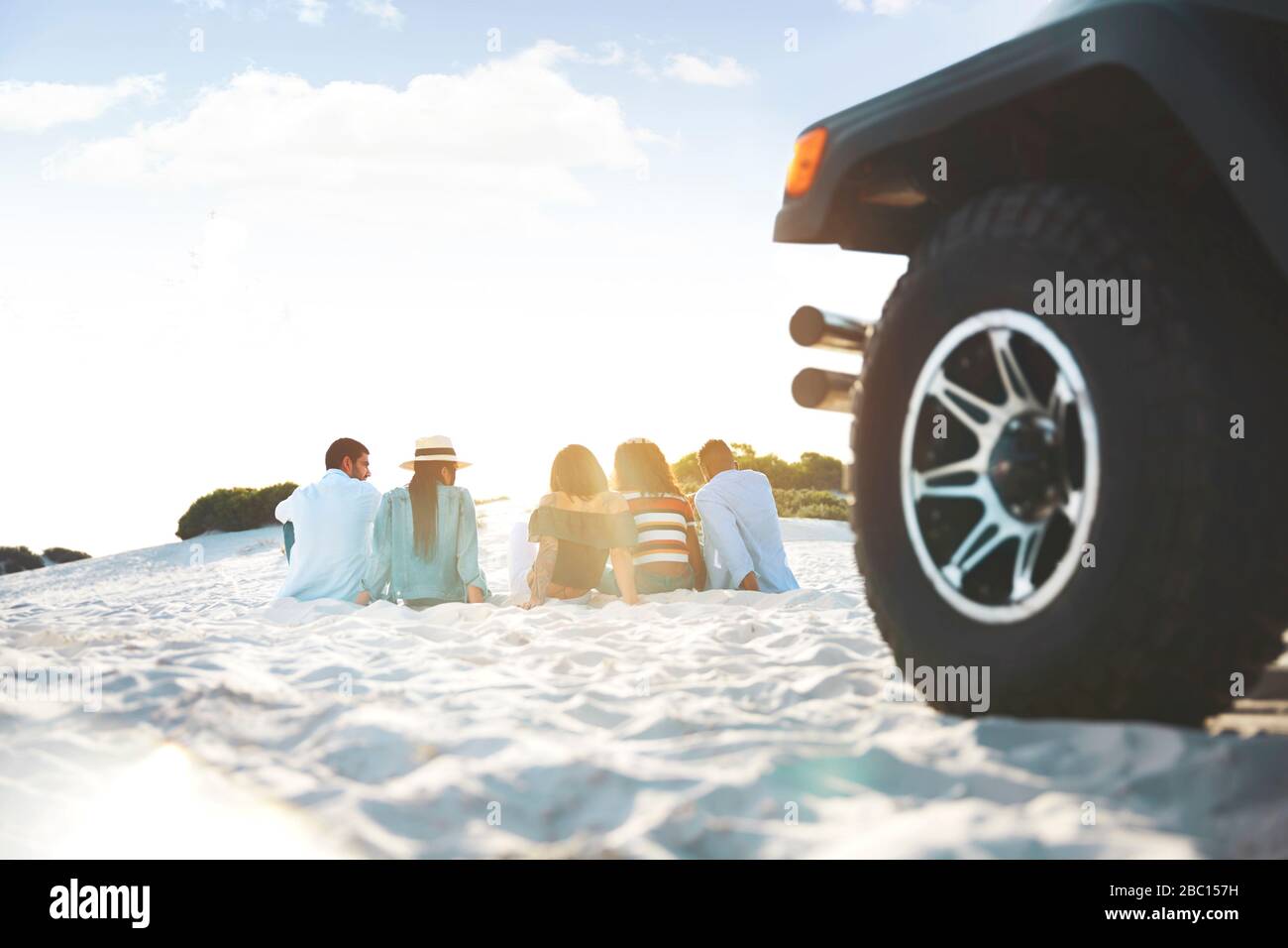 Junge Freunde entspannend, am Strand hinter Jeep hängen Stockfoto