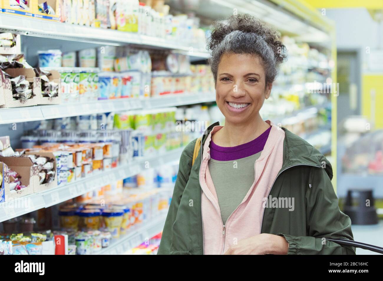 Portrait lächelnde, selbstbewusste Frau, die im Supermarkt einkauft Stockfoto