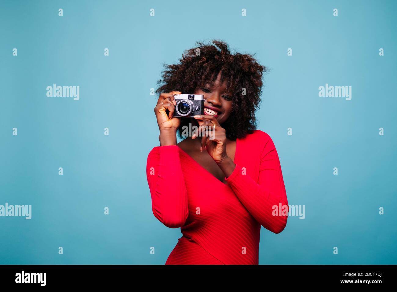 Porträt der glücklichen jungen Frau mit Vintage-Kamera im Studio Stockfoto Porträt der glücklichen jungen Frau mit Vintage-Kamera im Studio Stockfoto