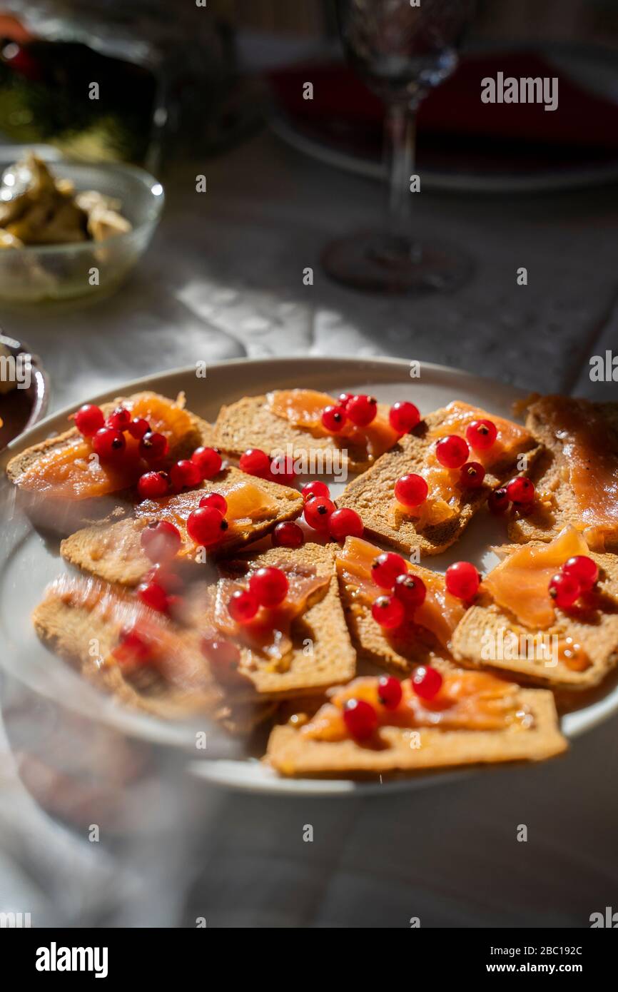 Spanien, Tablett mit Knäckebrot mit rohem Lachs und roten Johannisbeeren Stockfoto