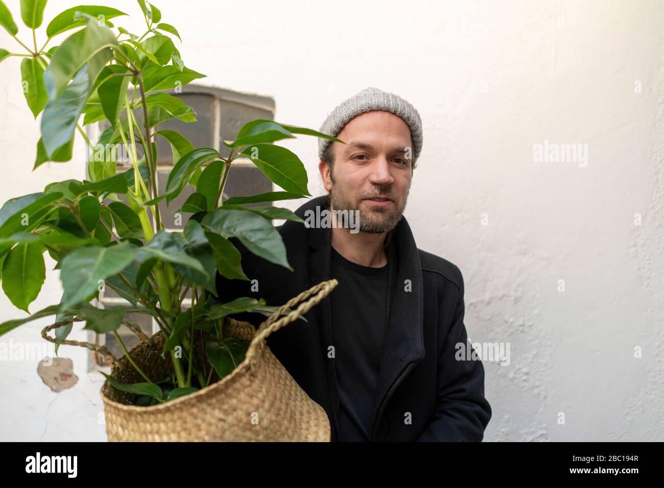 Porträt des Mannes, der eine Pflanze trägt Stockfoto