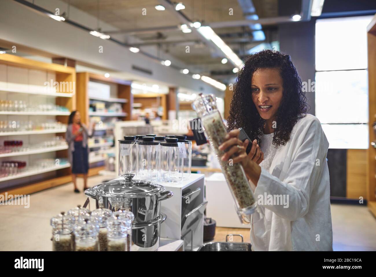 Frau kauft für Pfeffergrinder im Laden für Hauswaren ein Stockfoto