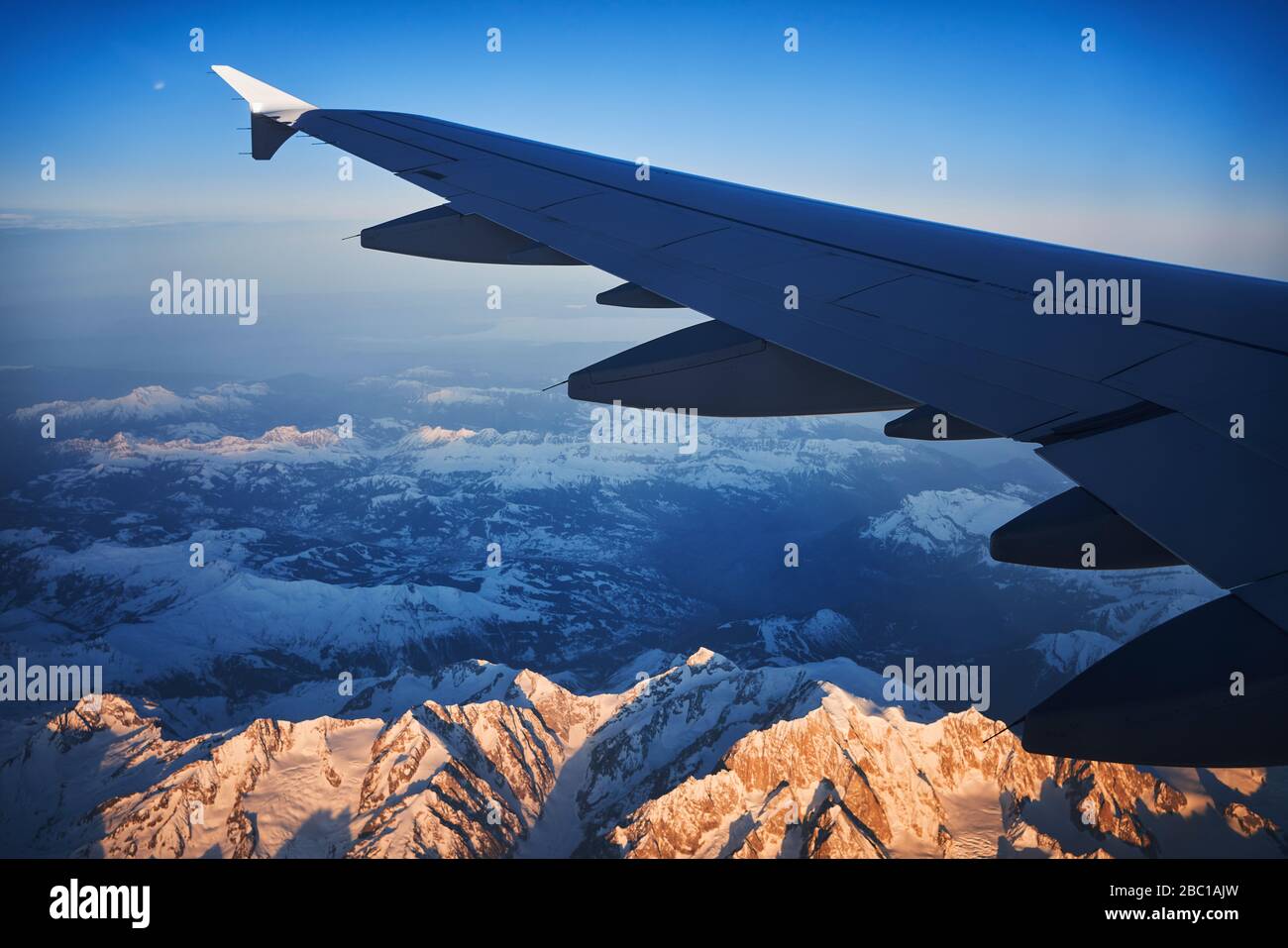 Frankreich, Auvergne-Rhone-Alpes, Flügel des Airbus A321, der im Morgengrauen über die europäischen Alpen und den Genfer See fliegt Stockfoto