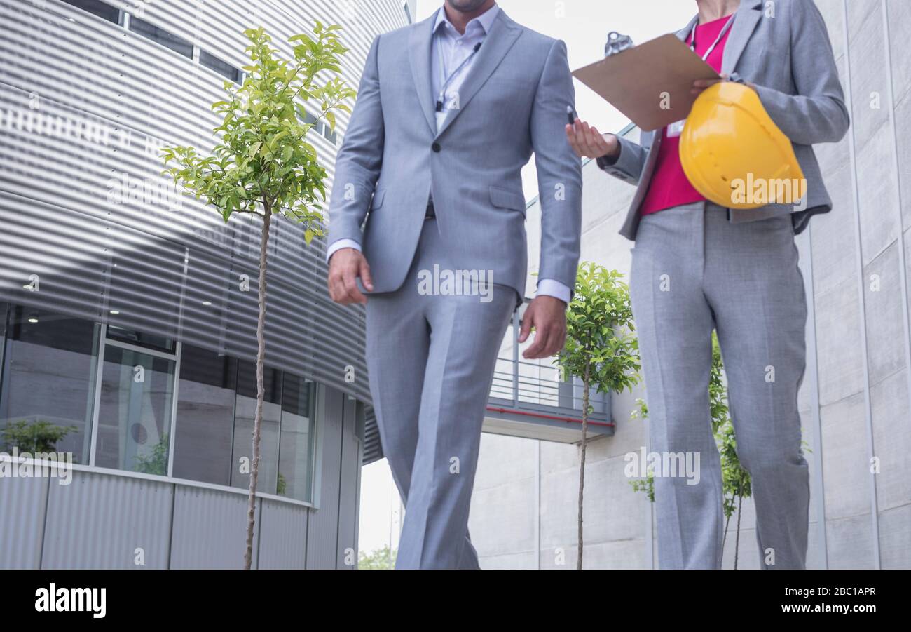 Vorgesetzte mit Hut und Clipboard gehen und sprechen Stockfoto