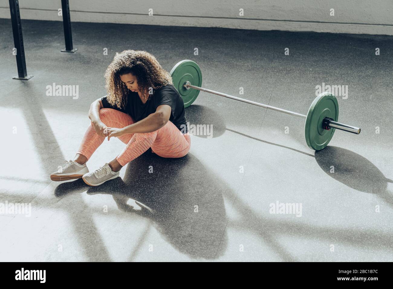 Junge Frau, die eine Pause von der Ausübung im Fitnessstudio Stockfoto