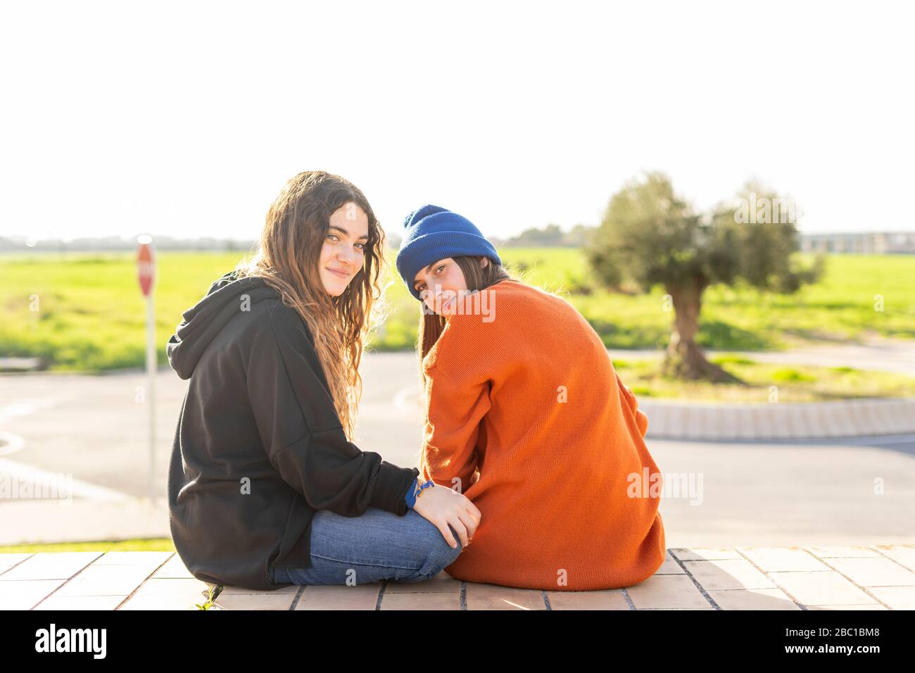Porträt von zwei Mädchen im Teenageralter sitzen im Freien Stockfoto