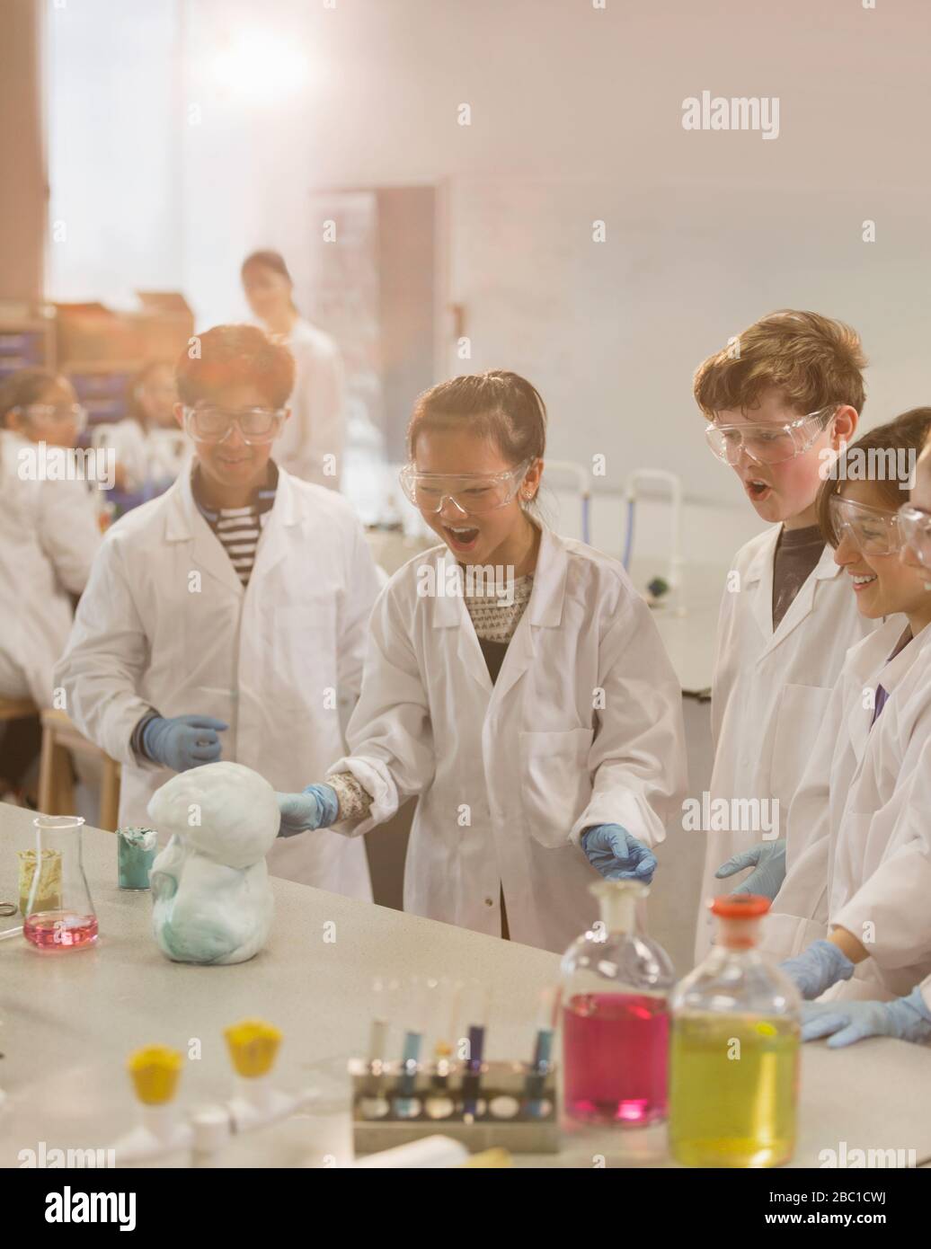 Überraschte Studenten, die explodierende wissenschaftliche Schaum-Experimente im Klassenraum-Labor durchführen Stockfoto