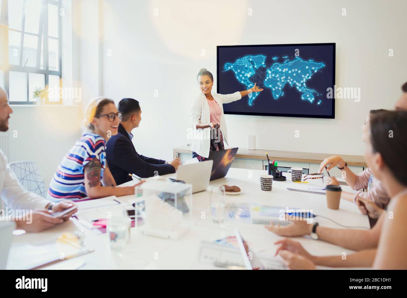 Designerin auf Fernsehbildschirm führt Konferenzraum-Meeting durch Stockfoto
