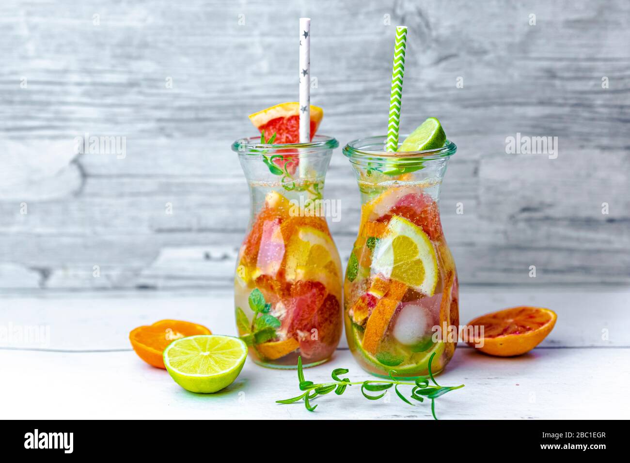 Gläser mit Wasser mit verschiedenen Zitrusfrüchten, Minze und Rosmarin Stockfoto