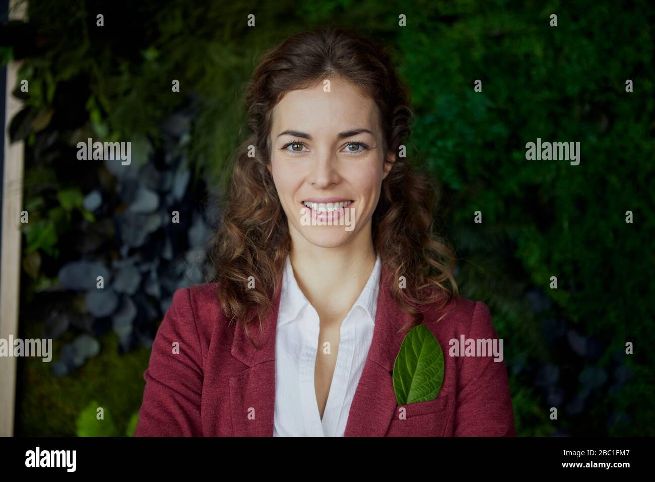 Portait der lächelnden Geschäftsfrau im grünen Büro Stockfoto