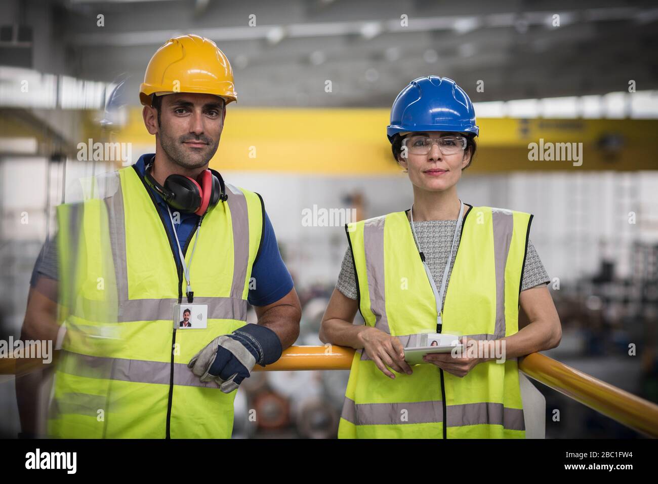 Hochformatige Supervisoren mit digitalem Tablet auf der Plattform im Werk Stockfoto