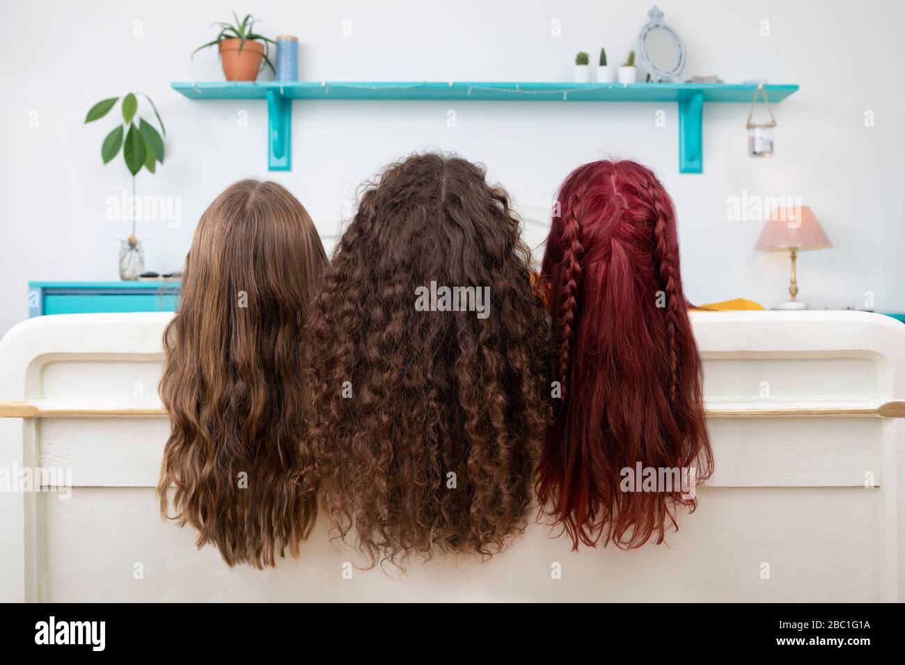 Rückansicht von drei Schwestern mit langen Haaren Stockfoto