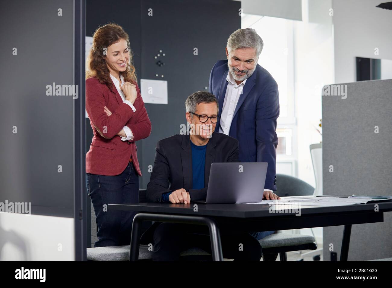 Zwei Geschäftsleute und Geschäftsfrau arbeiten zusammen an einem Projekt im Büro Stockfoto
