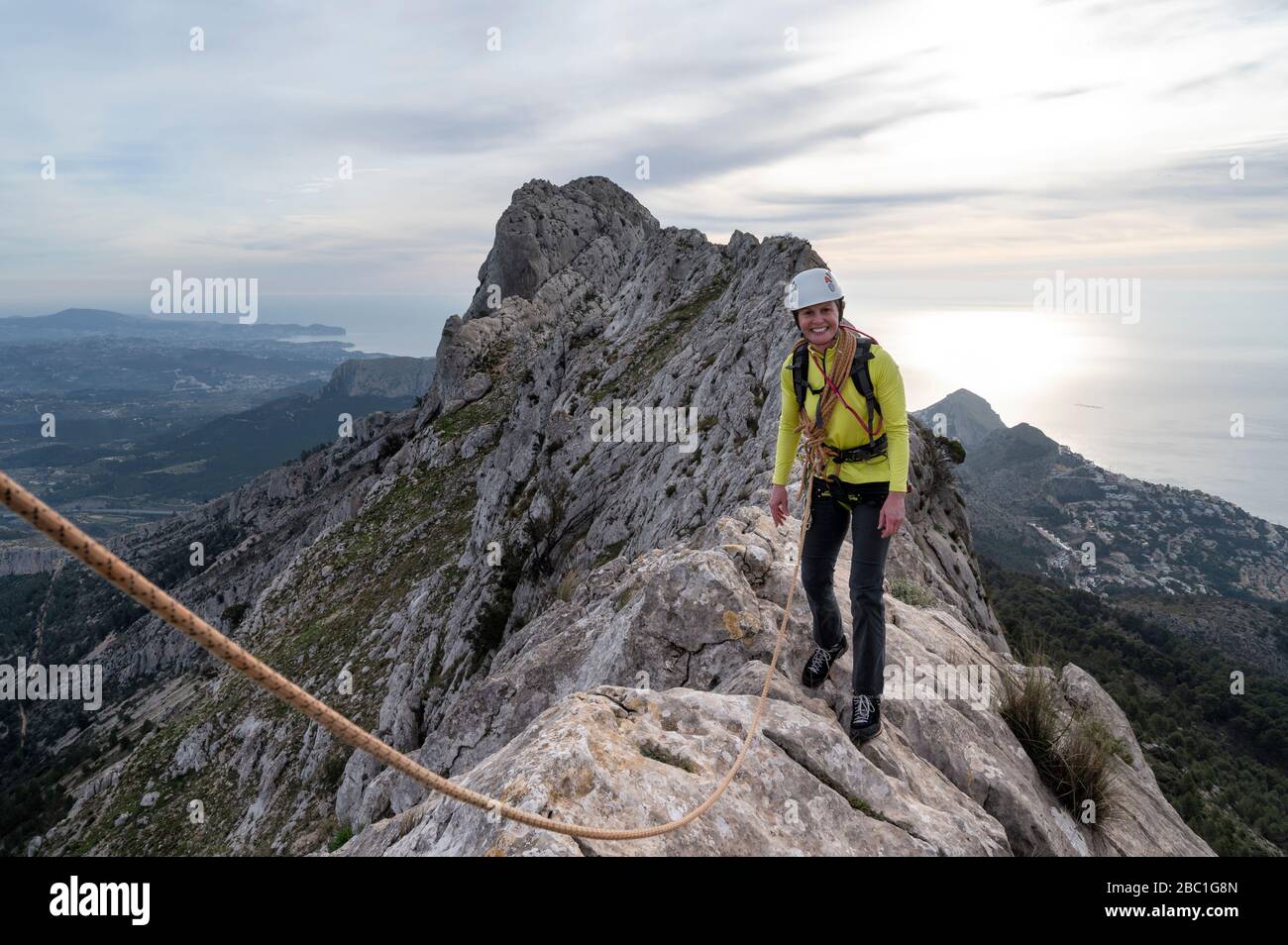 Lächelnde Frau Bergsteigen an Bernia Ridge, Costa Blanca, Alicante, Spanien Stockfoto
