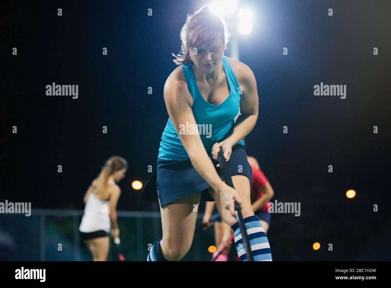 Entschlossener junger Feldhockeyspieler, der Sportübung ausübt Stockfoto