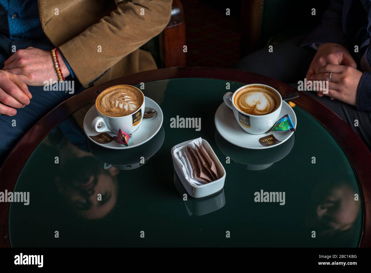 Ein Paar, das den Service und die Aufmerksamkeit mit zwei Tassen Kaffee genießt Stockfoto