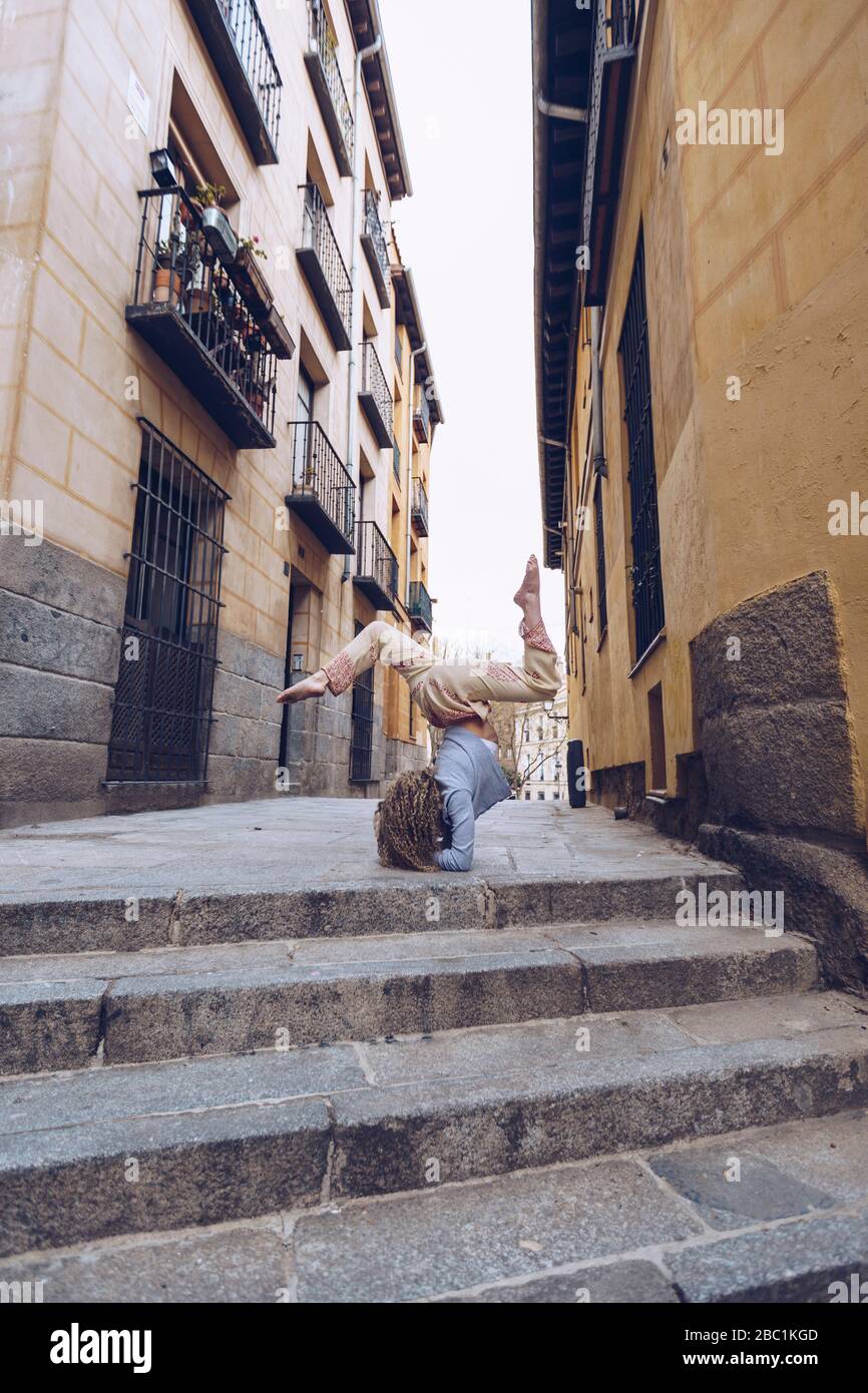 Junge Frau Yoga in der Stadt, die Durchführung Unterarm stehen auf der Straße Stockfoto