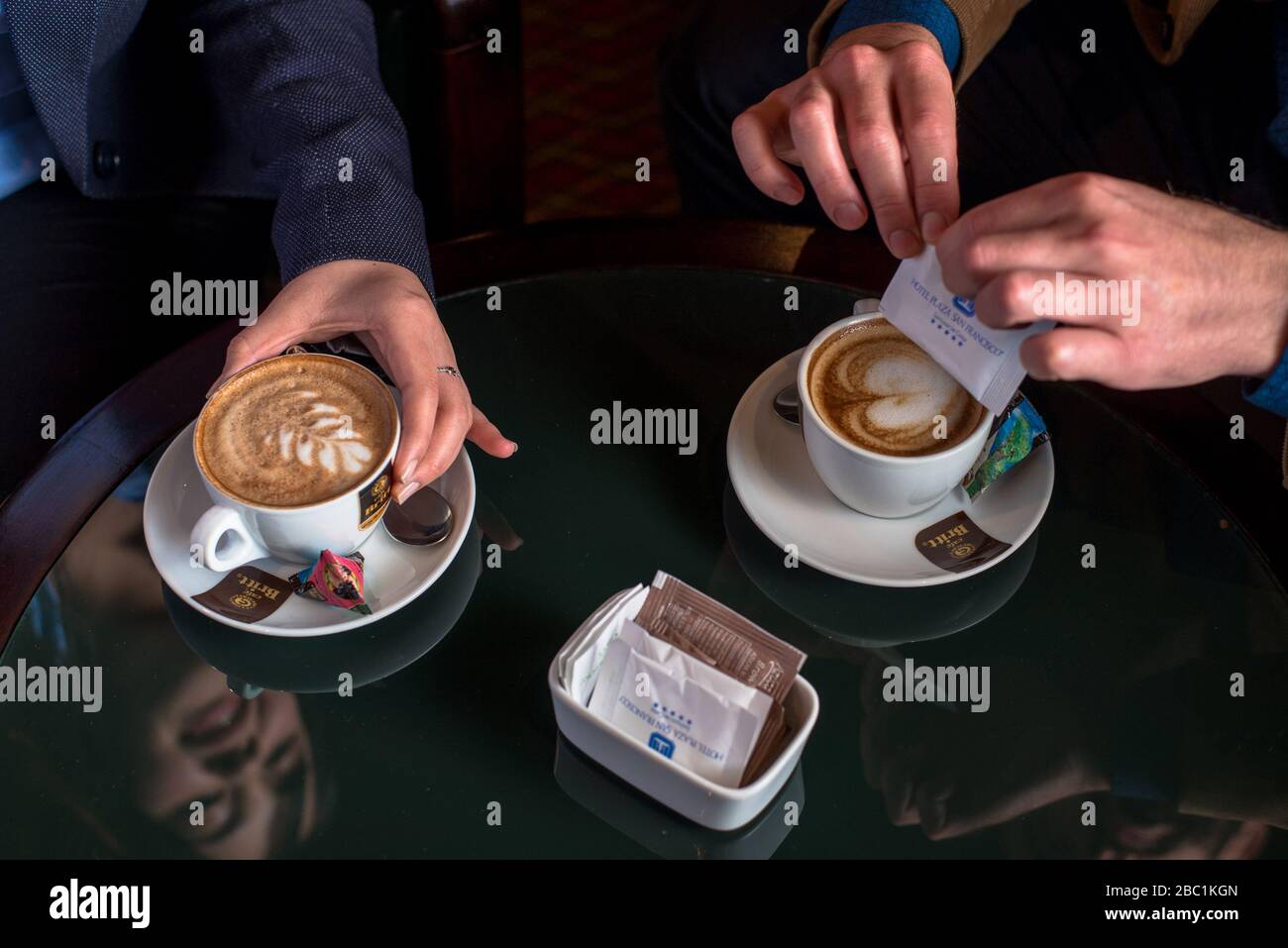 Ein Paar, das den Service und die Aufmerksamkeit mit zwei Tassen Kaffee genießt Stockfoto