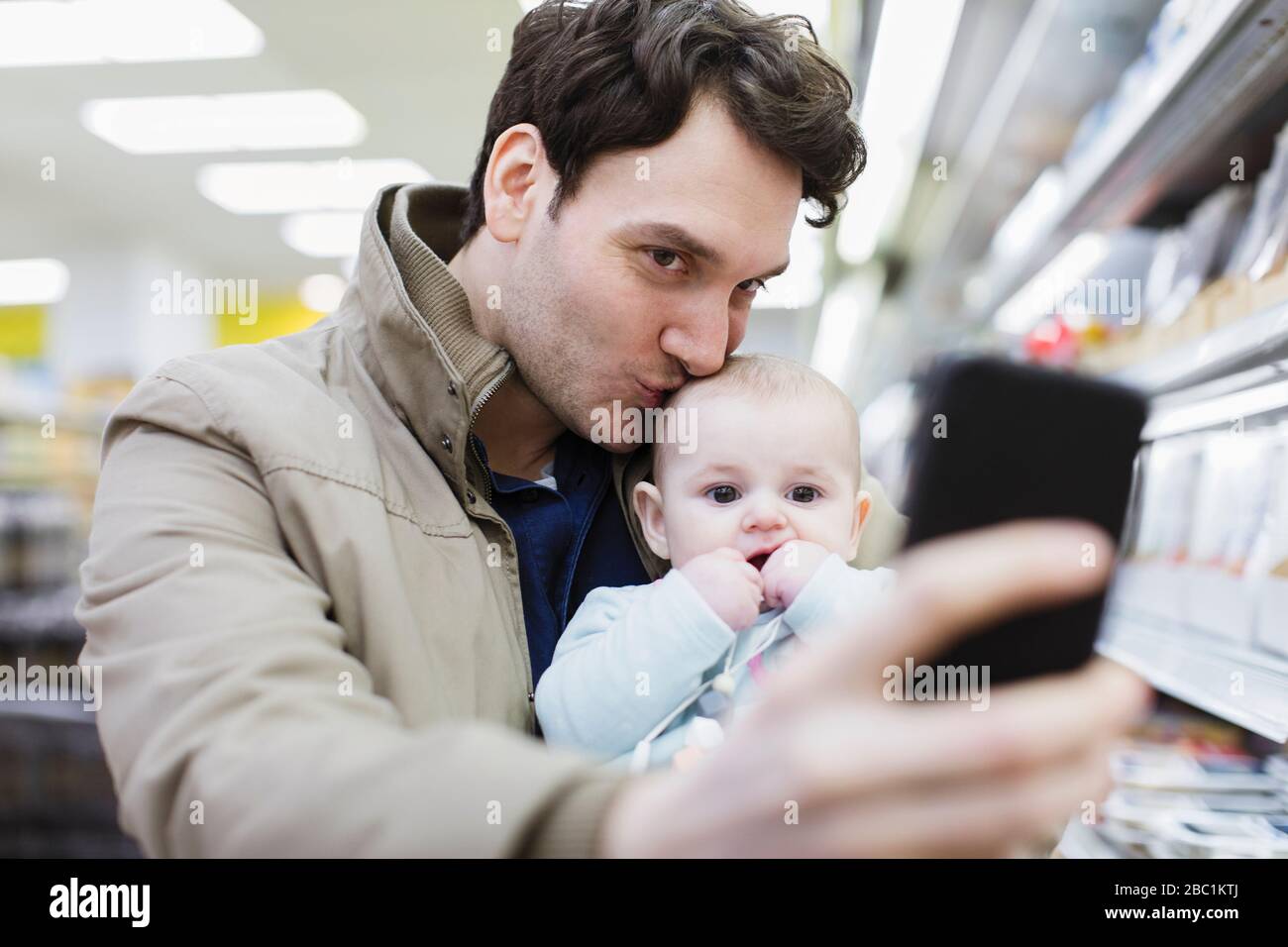 Liebevoller Vater und Tochter, die selfie im Supermarkt einnehmen Stockfoto