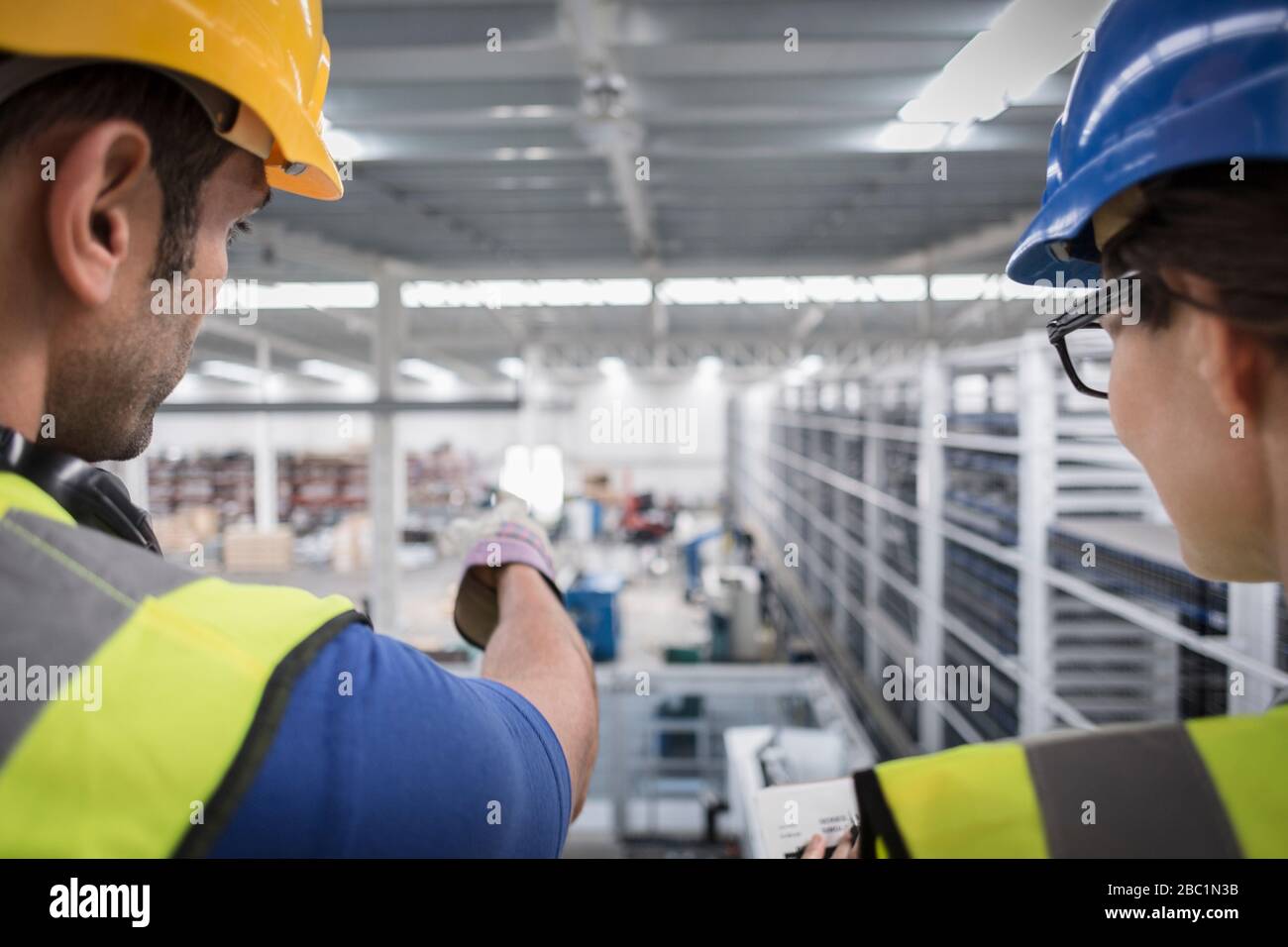 Vorgesetzte sprechen und zeigen auf die Plattform im Werk Stockfoto