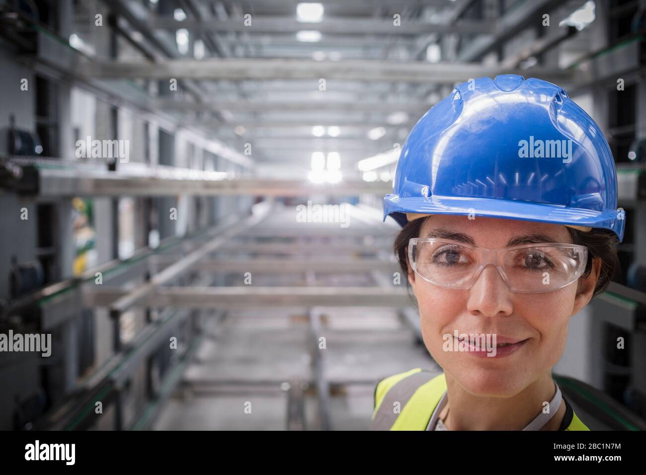 Portrait selbstbewusste, lächelnde Arbeiterin der Stahlfabrik Stockfoto