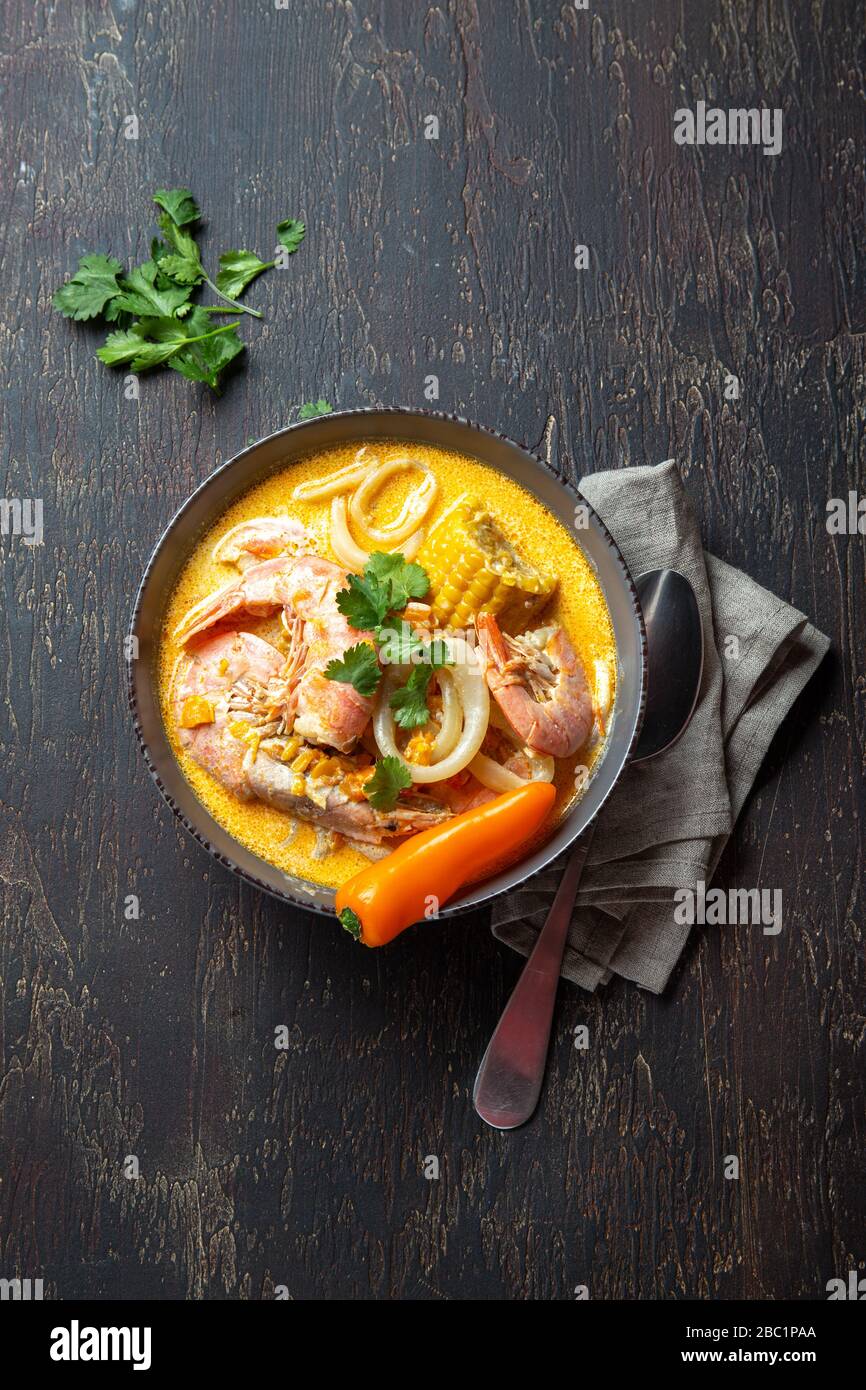 Peruanische Meeresfrüchtesuppe Chupe de Camarones in grauer Schüssel, Draufsicht. Stockfoto