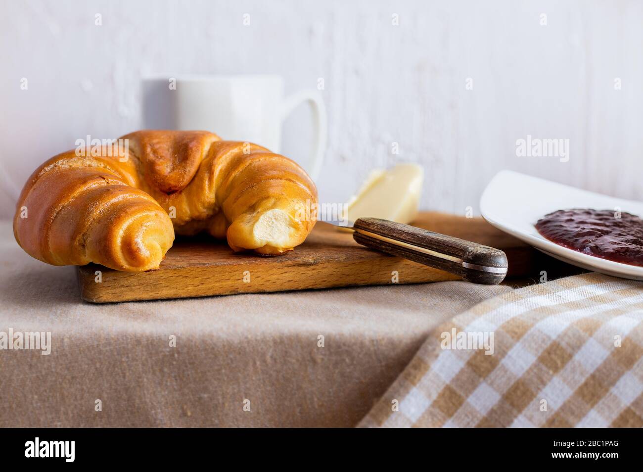 Frühstück mit Buttercroissant und Pflaumenmarmelade. Ein leckerer Morgen. Hintergrund für Restaurants. Polnisches Gebäck. Stockfoto