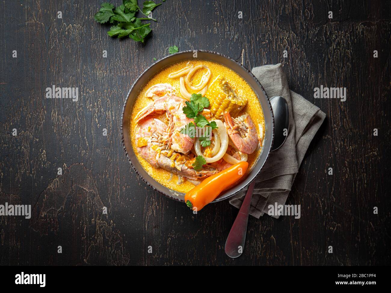 Peruanische Meeresfrüchtesuppe Chupe de Camarones in grauer Schüssel, Draufsicht. Stockfoto