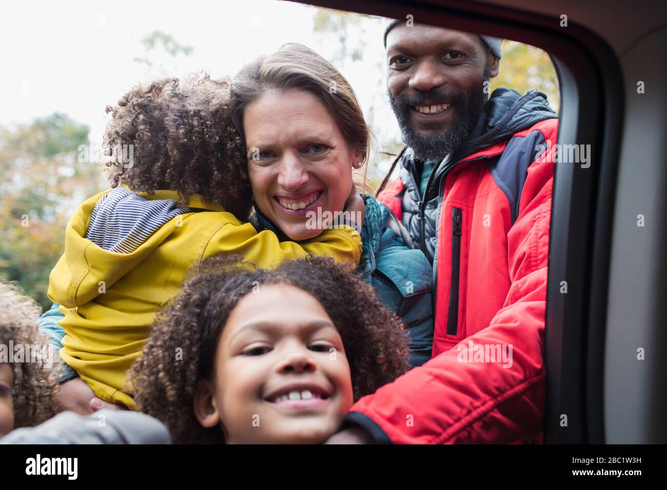 Portrait fröhliche multiethnische Familie am Autofenster Stockfoto