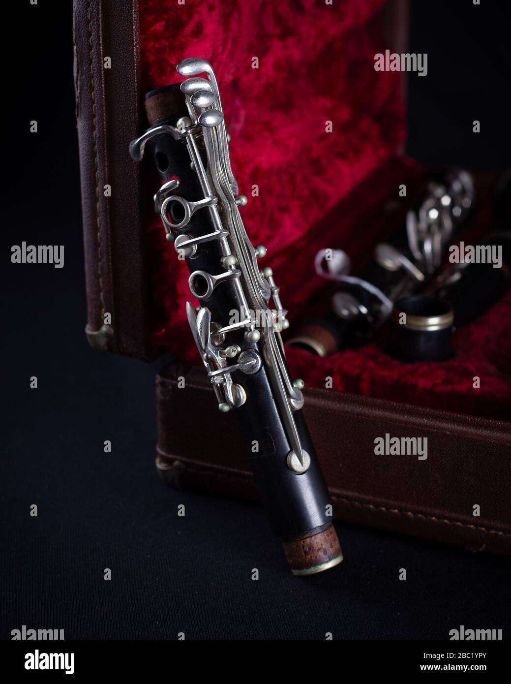 Vintage Bundy Wood Body Clarinet im Original Red Velvet-Lined Hartschalenstiel auf dunklem Hintergrund Stockfoto