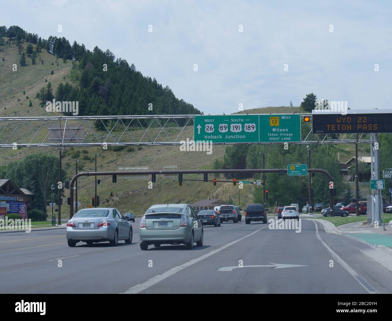 Jackson Hole, Wyoming- August 2018: Autos staunen auf der Straße mit Richtungsschildern zu verschiedenen Zielen in Jackson Hole. Stockfoto